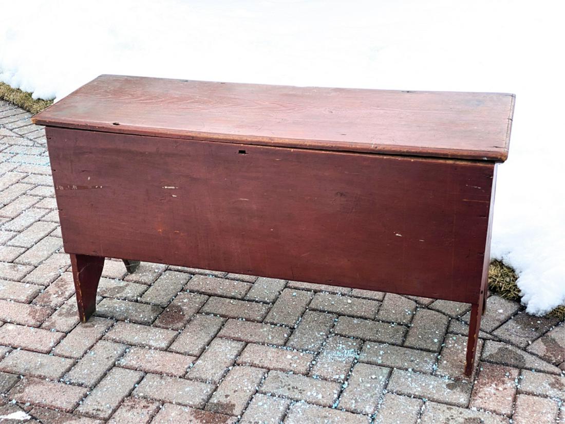 (19th c) BLANKET CHEST in RED PAINT: Bootjack ends with molded top that opens to till and snipe hinges. 26 x 49 x 16 1/2 inches