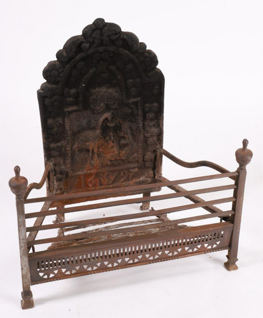 1697 GEORGE III STORK & FOX CAST IRON FIRE BASKET: Cast iron William and Mary fire back bolted to an iron fire basket with urn finials. 27 x 25 x 13 inches
