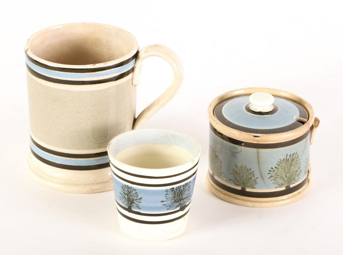 (3) PIECES OF ENGLISH MOCHA WARE: Including: Banded pint mug, Egg cup with band of trees and a Covered sugar bowl with band of trees. 3 3/4 inches
