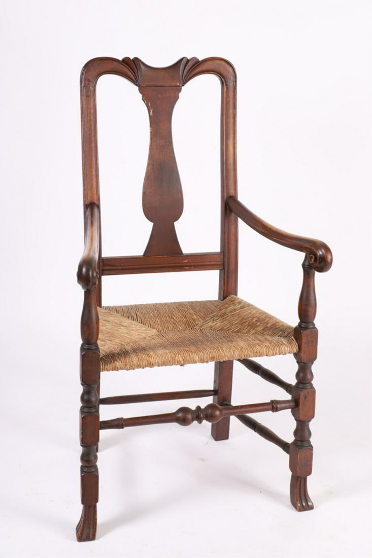 WILLIAM AND MARY TRANSITIONAL ARMCHAIR: Comet carved crest, vasiform splat, molded and scrolled arms, rush seat, block and vase turned legs and Spanish feet. 43 x 24 x 18 inches. seat 18 inches