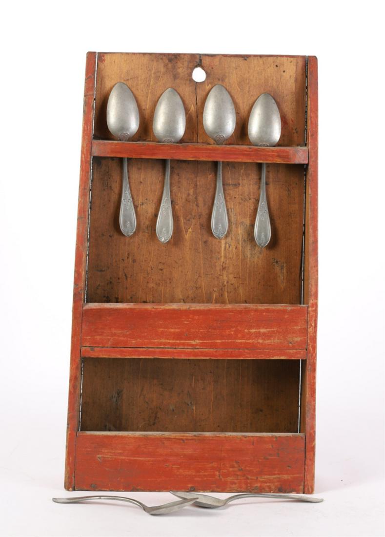 (19th c) SPOON RACK RED WASH: Shaped ends support (4) Spoon rack over and (2) lower boxed shelves. Together with (6) pewter tablespoons. 22 x 12 1/2 x 3 3/4 inches.