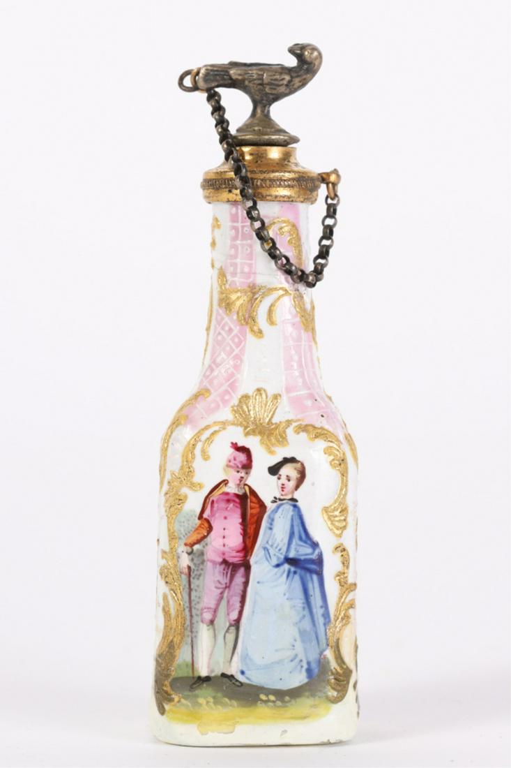 (18th c) CHELSEA PORCELAIN PERFUME BOTTLE: Bird-form stopper on chain surmounts porcelain font hand painted with romantic couple and busy port scene each framed with rococo inspired gold scrolls on a ground of raised diaper patterns.