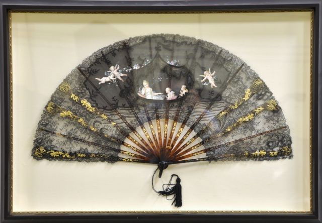 Shadow box Framed fine Victorian Fan: Having Black Lace hand painted with a classical scene of a beauty with winged cherubs with garland flanked with gold fruit die cut putti, having gilt enameled tortoise shell sticks 15 X 27 frame: 23 X