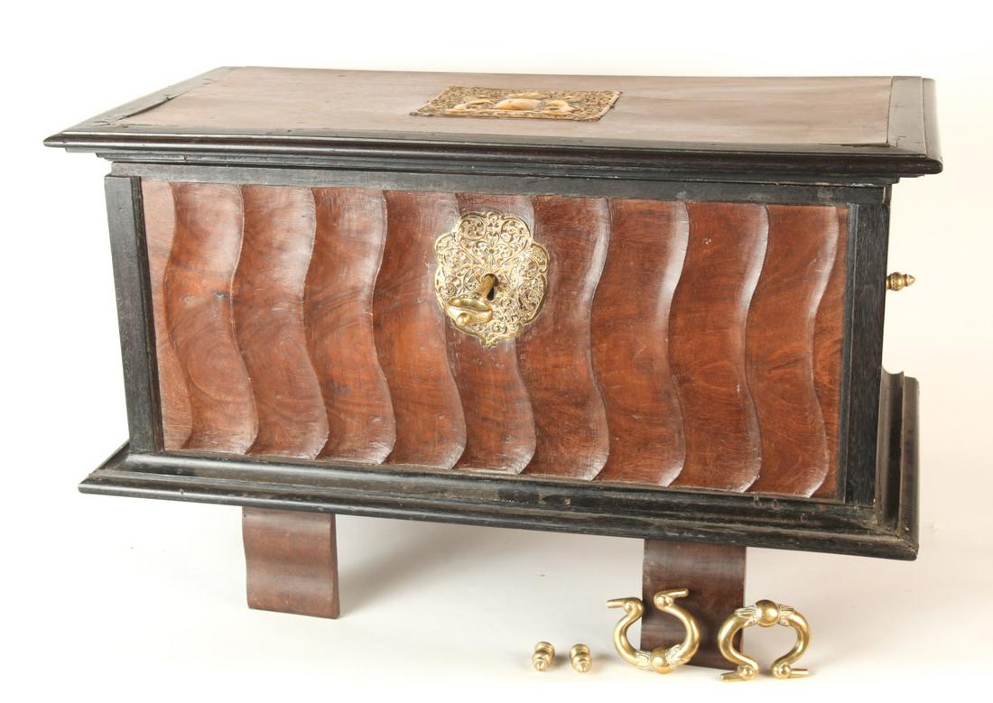 (19th c) EAST INDIAN CHEST of EXOTIC HARDWOODS: Contrasting exotic hardwoods with ogee carved front and sides inlaid with pierced brass armorial crest, matching escutcheons, impressive key and bail handles. 18 1/2 x 41 x 21 inches. N.B. Not dissimi