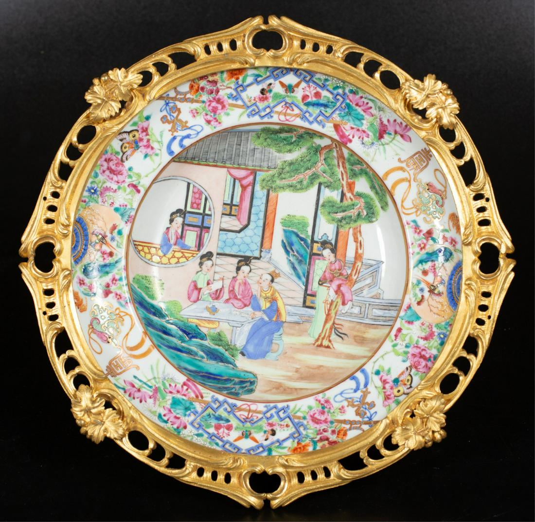 ORMOLU MOUNTED (19th c) FAMILLE BOWL: Finely cast and gilt mount raises dished porcelain plate with (4) acanthus leaf-form legs. 3 3/4 x 12 inches Condition: Good Temp No 6433