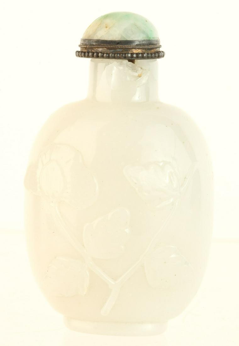 CHINESE FLORAL CARVED WHITE JADE SNUFF BOTTLE: Similar motifs carved on both sides. 3 1/4 inches. Provenance: Purchased at auction in the 1940s by the consignor's grandfather Condition: Loss and repair to neck Temp No 6139