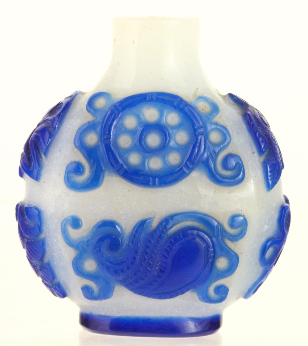 CHINESE PEKING GLASS SNUFF BOTTLE: Cobalt cut to opaque white with baskets, flowers and other geometric designs. 2 1/4 inches. Provenance: Purchased at auction in the 1940s by the consignor's grandfather Condition: Cap absent Temp No 6