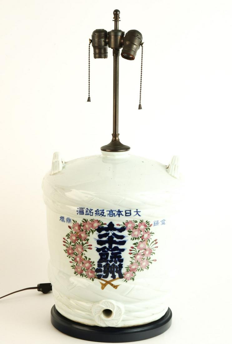 CHINESE WATER COOLER-FORM PORCELAIN TABLE LAMP: (20th c) Decorated with characters and floral motifs. 28 x 13 inches Condition: Good Temp No 6422