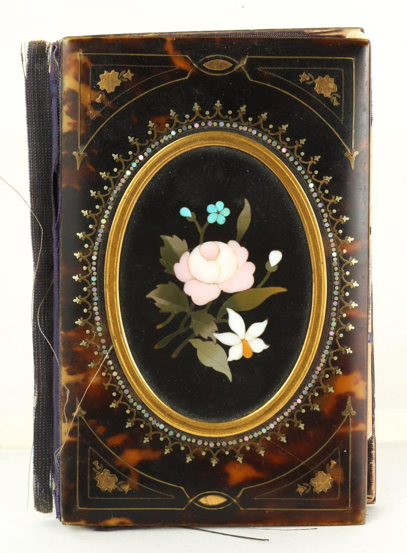 FABULOUS GRAND TOUR POCKET NOTEBOOK: Shell bound with gold and mother of pearl inlay and a central floral pietra dura. Carved bone pencil. 3 3/4 x 2 1/2 inches. Condition: Silk lining torn, pages unbound. Temp No 4279