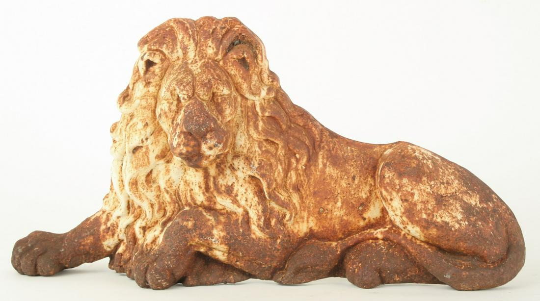 CAST IRON FIRE DOG OF RECUMBANT LION: Painted in white. 13 1/4 x 26 1/4 x 10 inches.
