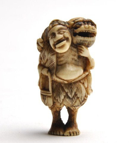 Japanese carved ivory netsuke of a man: Japanese carved ivory netsuke of a man with foo dog on shoulder with movable ball in mouth. H: 1 7/8"