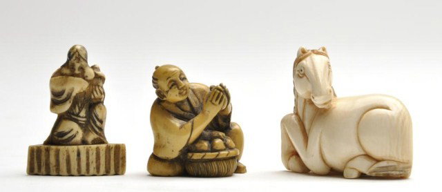 Three Japanese ivory netsuke: Three Japanese ivory netsuke, the first of Okame standing on a large fan, the next of a townsman making rice cakes, the last of a recumbent horse. H: 1 1/2" (first)