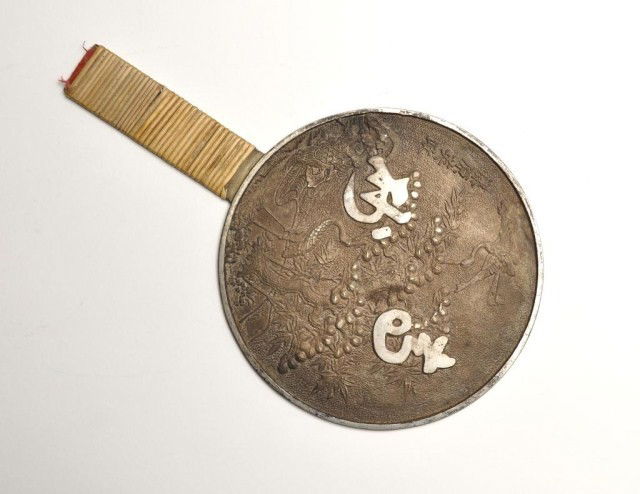 Japanese cast metal hand mirror: Japanese cast metal hand mirror, with raised bird and flower decoration, signed. L: 9"