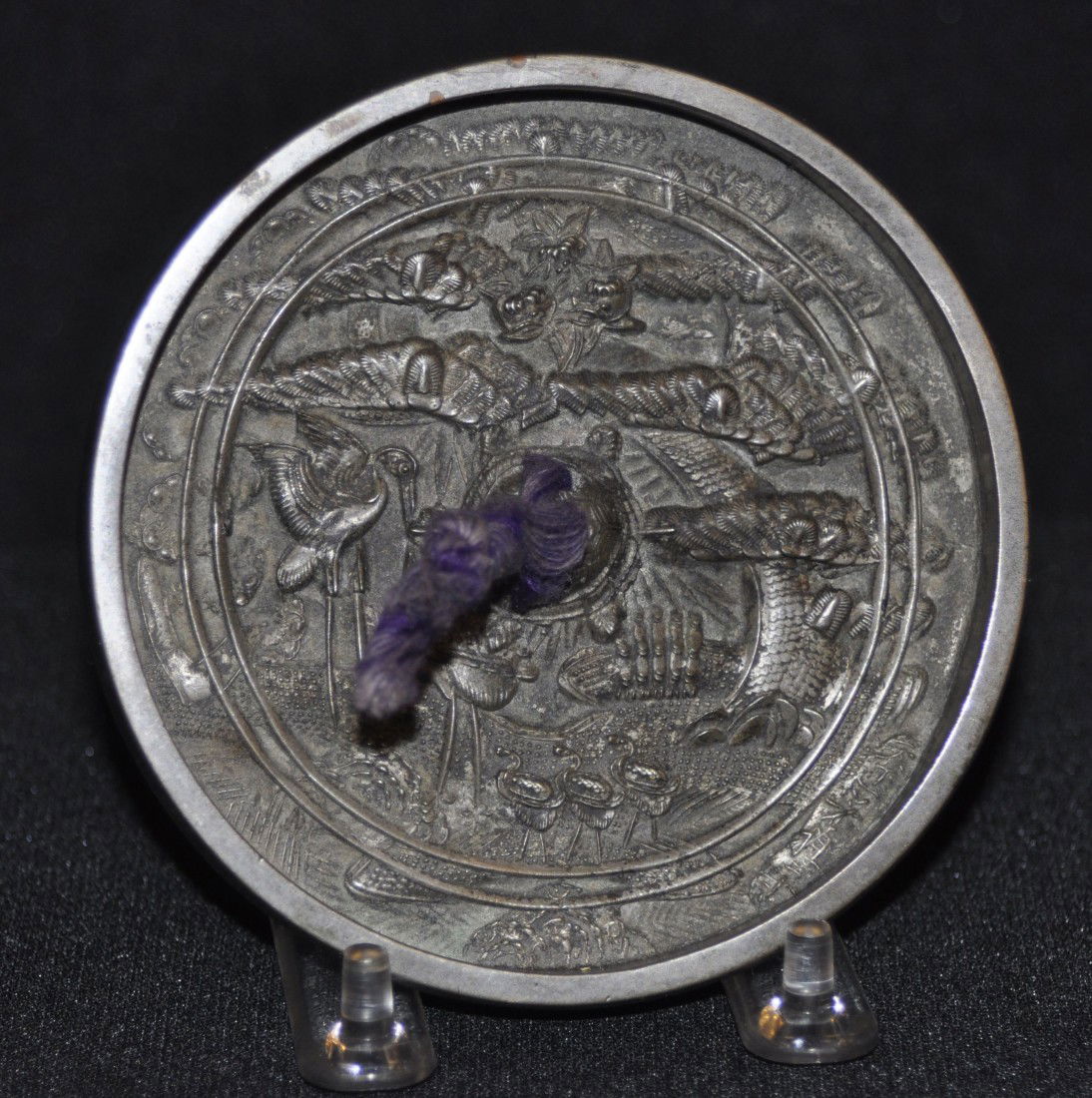 Cast bronze hand mirror: Cast bronze hand mirror decorated with birds and trees, signed. D: 4 3/8"