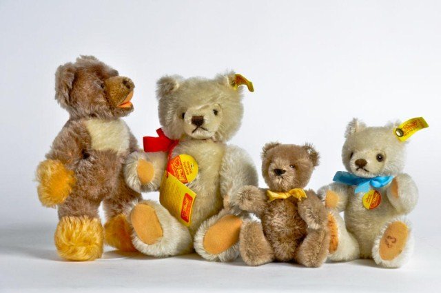 Group of four Steiff teddy bears consisting of: two whtie with gold buttons and tags; one signed Michael Steiff ' 83 on feet and two brown bears with silver buttons and tags; tallest: 9 1/2"