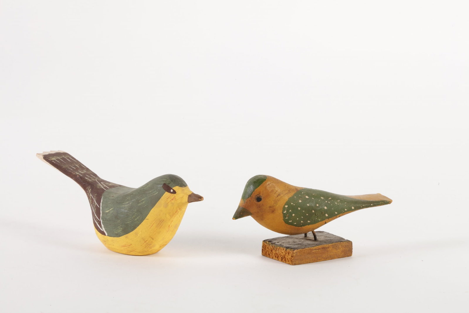 (2) CARVED WOOD AND PAINTED SONG BIRDS: Hand carved & painted. One mounted on a wood stand. 4 1/4 and 5 inches.