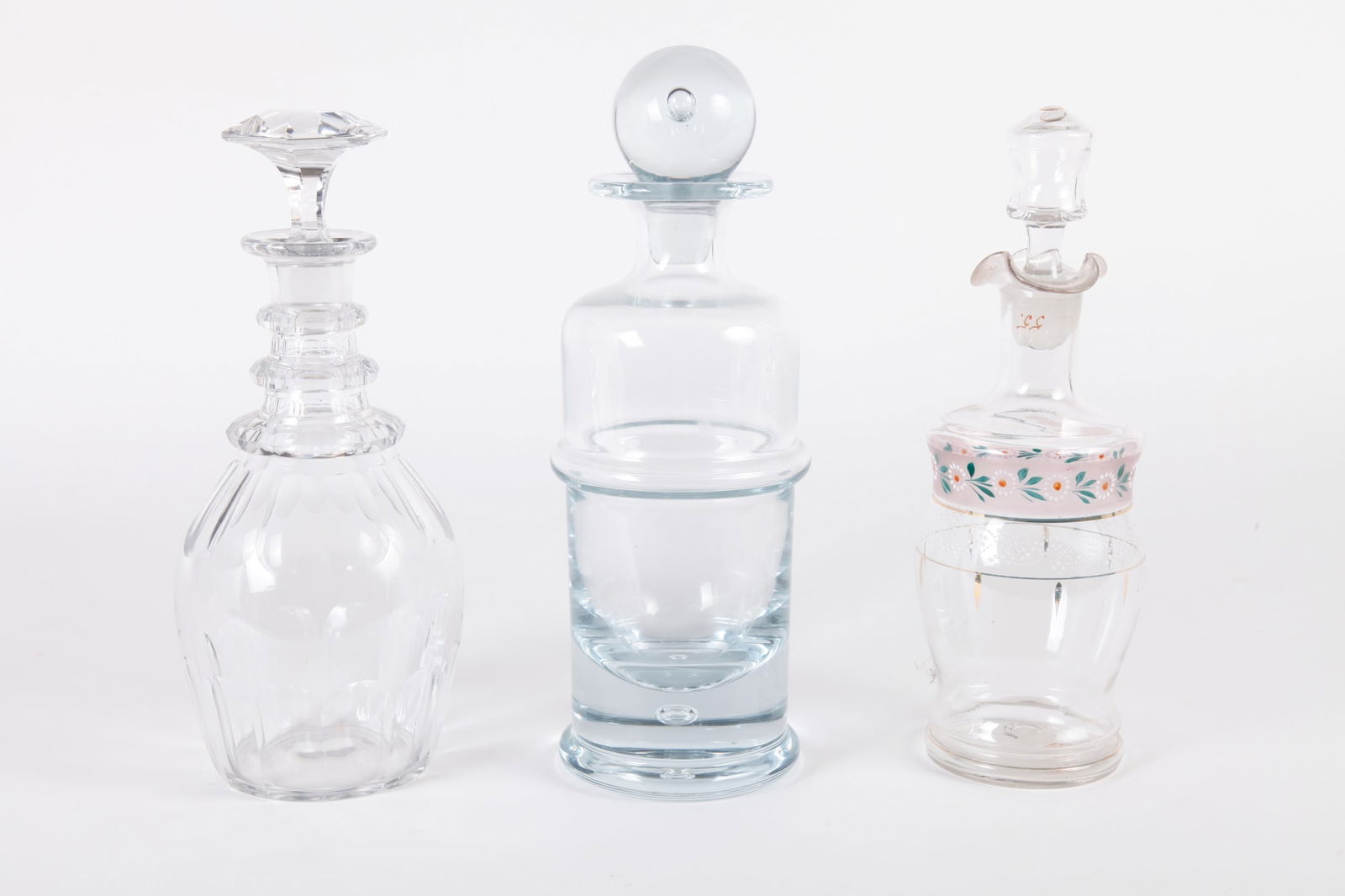 (3) VINTAGE CLEAR GLASS DECANTERS INCLUDING: A Holmegaard Regiment decanter. Tallest is 12 inches.