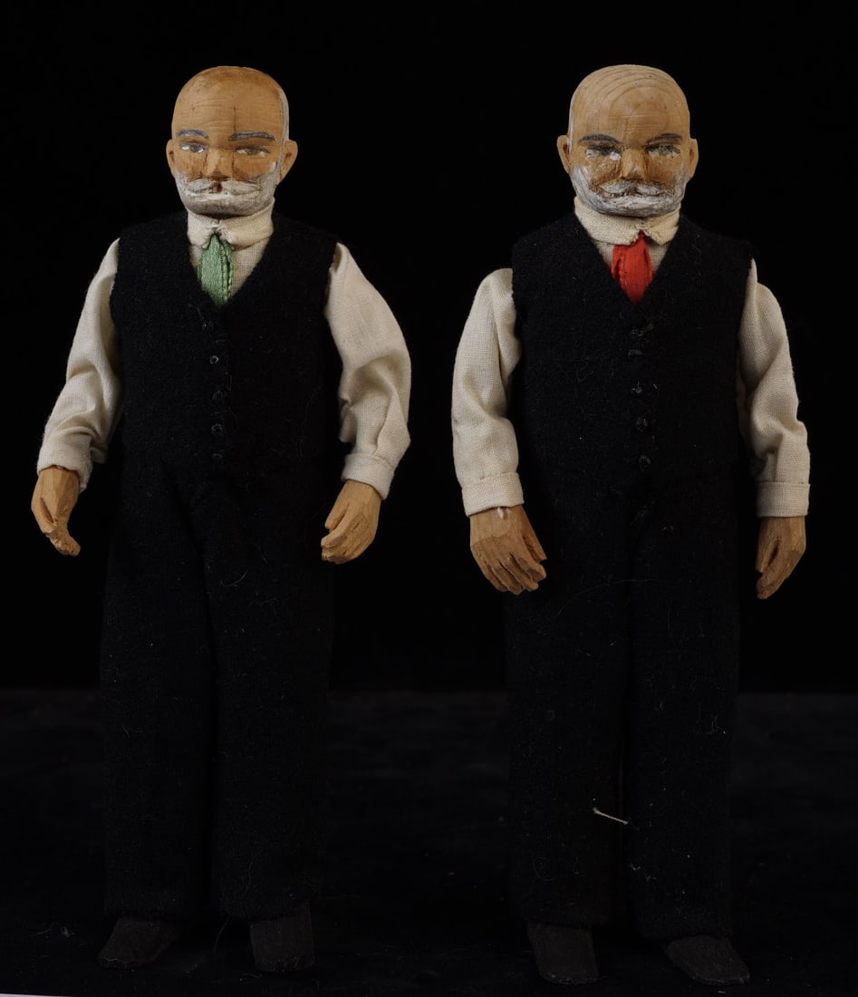 PR. SMALL CARVED WOOD & PAINTED DOLLS: Elderly gentlemen with carved head, hands and feet; each wearing black slacks and vest with white shirt; one with a red tie, one with a blue tie. Initials on bottom of foot: "M I W". 6 inches tall