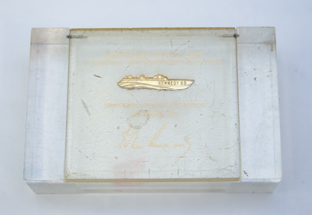 1960 HON. ROYAL DION DNC CIGARETTE BOX: Lucite cigarette box with inscription on lid "Honorable Royal Dion Chairman, New Hampshire Delegation", with embedded "Kennedy '60" bronze PT boat, "Democratic National Convention Los Angeles 1960". 1