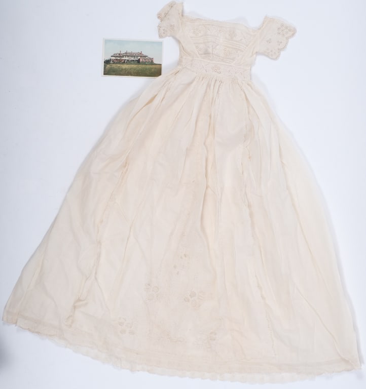 AUCHINCLOSS FAMILY CHRISTENING GOWN: Embroidered with cut and drawn work. 34 inches. Together with a color photograph of Hammersmith Farm. Provenance: Yusha Auchincloss archive from The Castle at Hammersmith Farm. Condition: