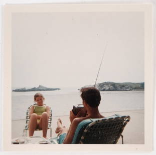 CAROLINE KENNEDY at BAILEYS BEACH, NEWPORT, RI: Sitting across from an unidentified man with a book. August 1968. color photograph 3 1/2 x 3 /12 inches. Provenance: Yusha Auchincloss archive from The Castle at Hammersmith Farm. Condition: