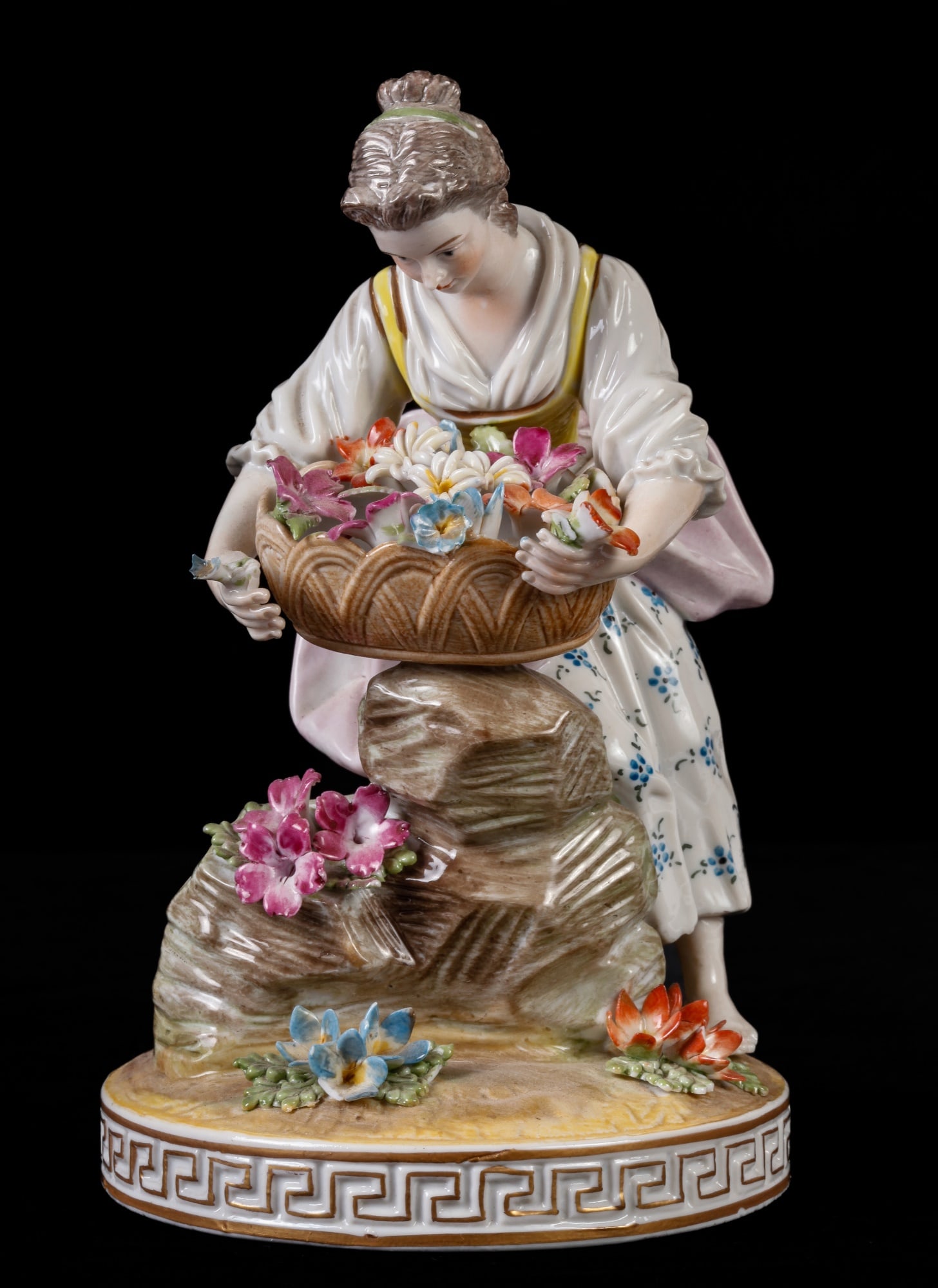 DRESDEN PORCELAIN FIGURINE: Depicting a woman carrying a large basket of flowers. 6 1/4"