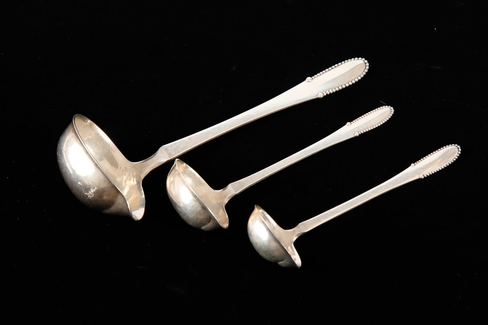 (3) GRADUATING GEORGE JENSEN STERLING LADLES: Largest measures 8 inches. 4.19 ozt.