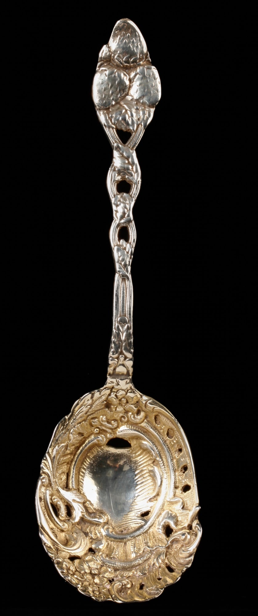 ROCOCO INFLUENCED STERLING SILVER BERRY SCOOP: Pierced bowl and handle with strawberry motif. 9 inches. 4.74 troy ounces