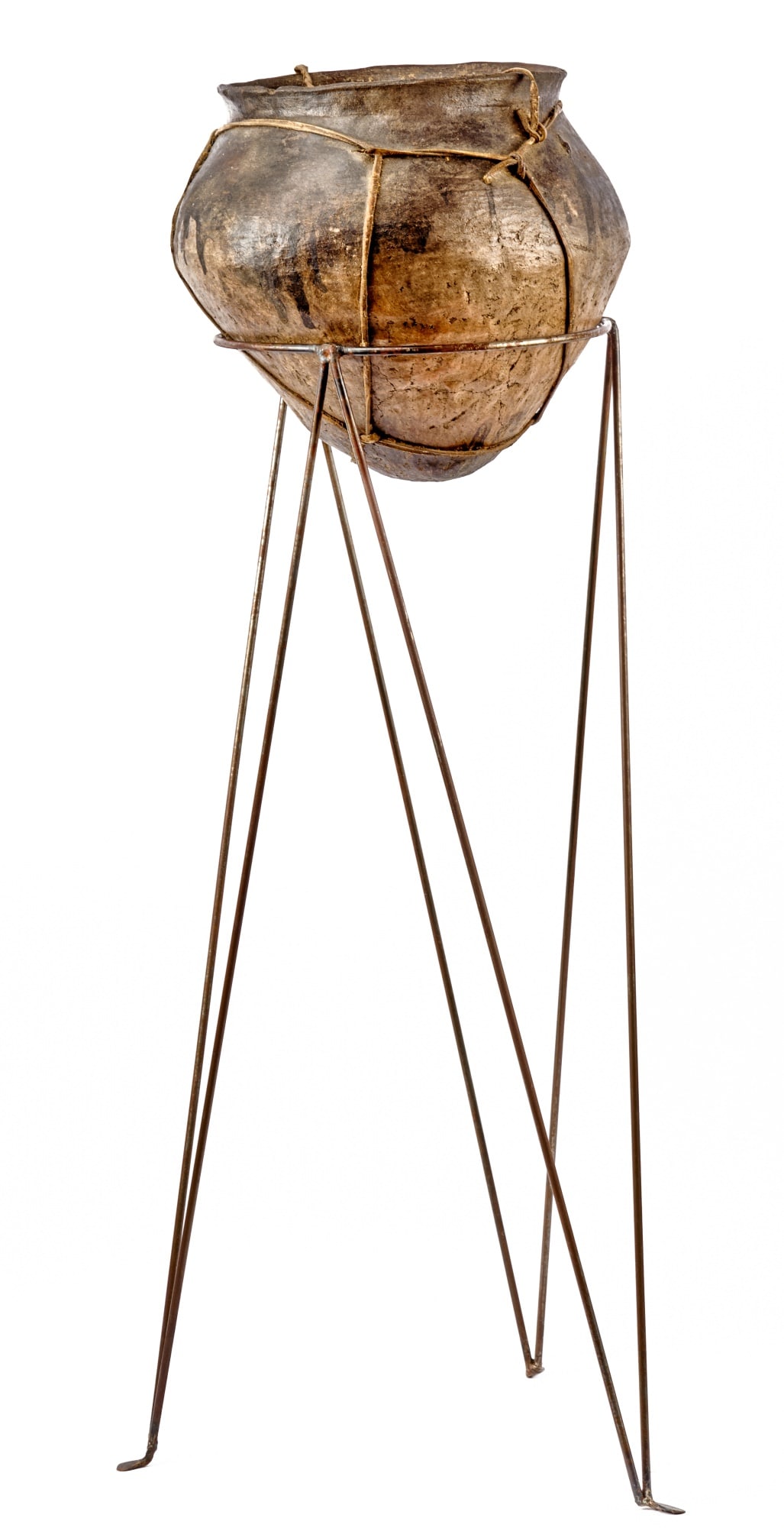 ANTIQUE LEATHER-BOUND TARAHUMARA TESQUINO POT: Used to make corn beer in Copper Canyon, Mexico. 12 x 11 inches. Together with a contemporary 32 inch steel stand. 39 inches (overall)