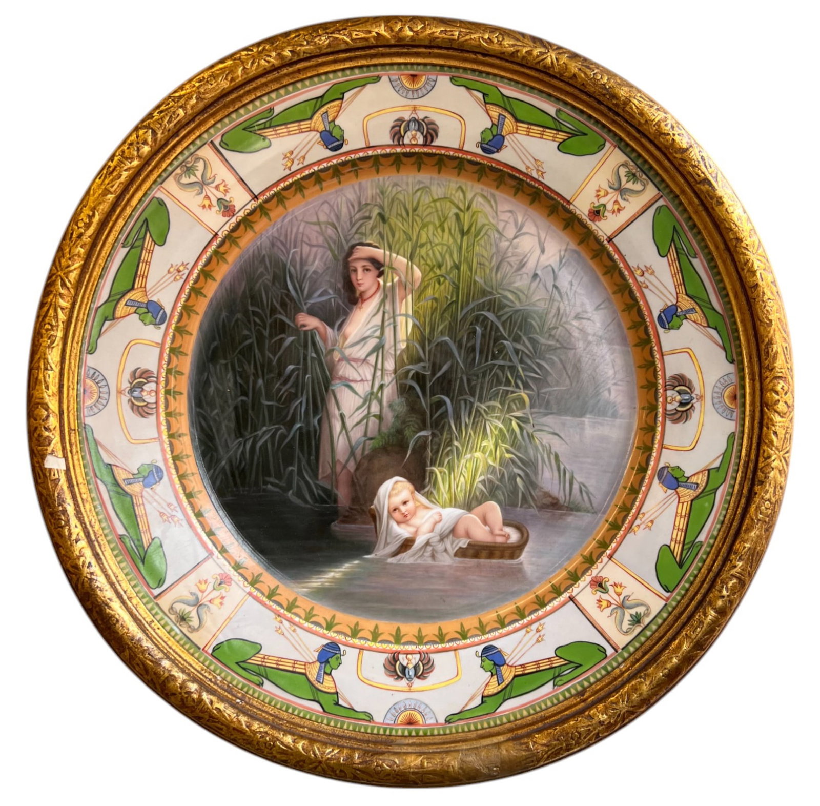 THE DISCOVERY of the INFANT MOSES: French porcelain plate with a hand painted scene depicting the discovery of the infant Moses with an Egyptian motif border, mounted in a gilt frame. Reverse stamped "14 000". 20 inch diameter includin