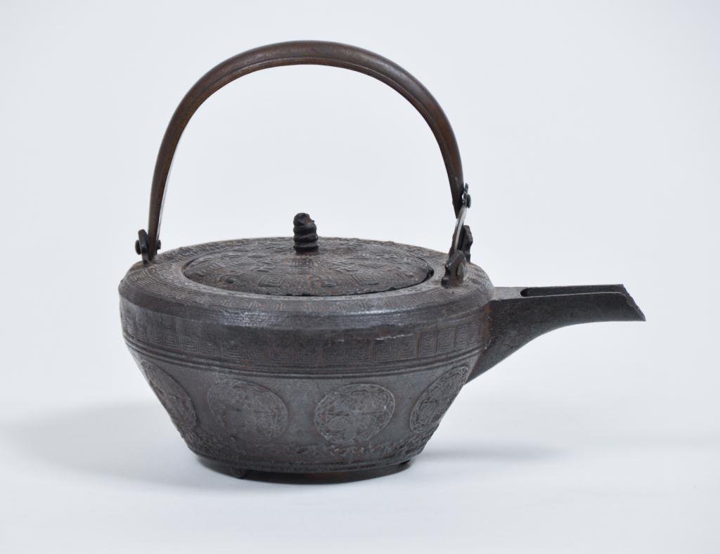 (19th c.) Japanese Cast Iron Tea Pot: Meiji period tetsubin with interesting raised motifs including medallions and bronze handle Condition: good Size: 7" x 9"good7" x 9"