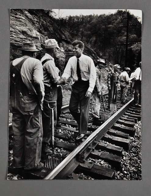 1960-May, J.F.K. Campaigning in West Virginia: (1) Large format photograph for "Life" Magazine of J.F.K., shaking hands with coal miners, 10 1/2" x 13", taken by Hank Walker. Condition: Good, minor creases, soft scratch