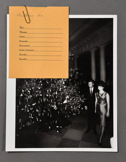 1961-Dec, J.F.K., Christmas: (1) Photograph with negative of J.F.K. with Jackie beside the White House Christmas Tree, 8" x 10". Condition: Paperclip impression