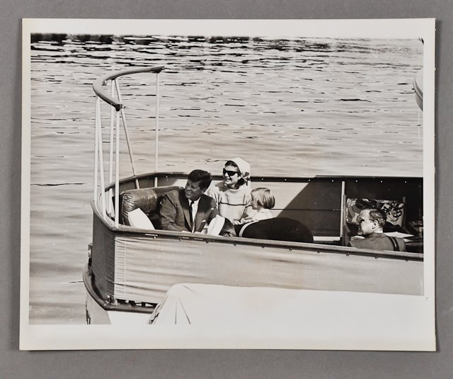 1962-July 13, J.F.K., "Family Outing": (1) Photograph of J.F.K., Jackie and Caroline aboard the "Honey Fitz," on July 13, taken by the Associated Press, 8" x 10". Condition: Good