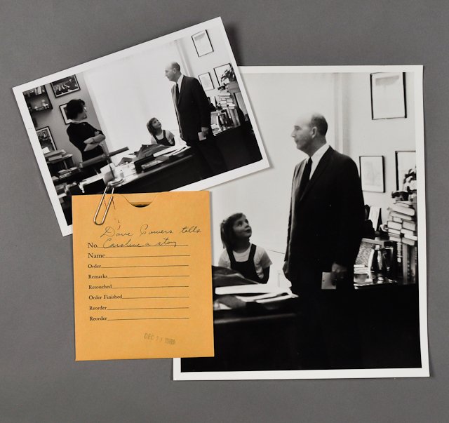 1962-Dec 4, D. Powers tells Caroline a Story: (1) Photograph of David Powers in office telling Caroline Kennedy a story on Dec. 4, 5" x 7". (1) Photograph and negative of a cropped version, 8" x 10". Condition: Paperclip impressions