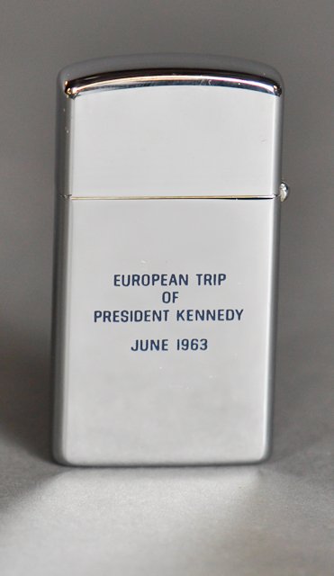 1963-June, J.F.K., Europe Trip, Rare Lighter: (1) Chrome Slim Zippo Lighter in its original box engraved in blue with the Great Seal of the President recto and "European Trip of President Kennedy June 1963" verso. 2 1/4" (2) Index cards with note