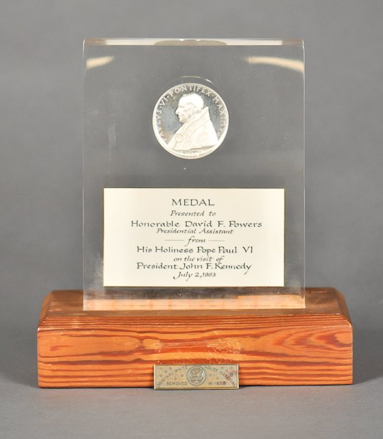 1963-July 2, J.F.K., Vatican City, Rome: (1) Medal presented to David Powers from Pope Paul VI. July 2. Encapsulated in Lucite. 8". Good. (1) Leather bound (11) page presentational pamphlet of J.F.K.'s visit to his Holiness. 8 1/2" x 6". Ton