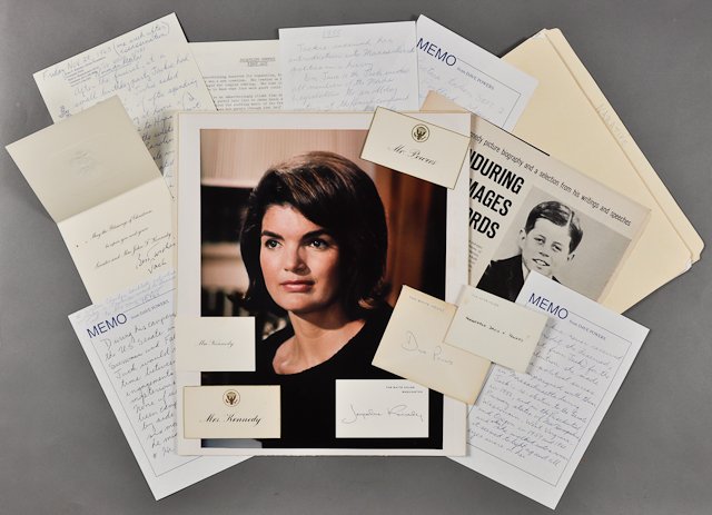1964-Jackie File: Dave Powers file on Jacqueline Kennedy including (1) Large format photograph of Jackie. 13" x 10". Mounted, soft surface abrasions, soiling. (3) Seating cards of Jackie and (1) of Mrs. Dave Powers. (1