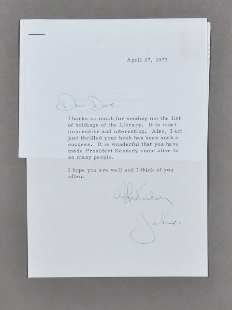 1973-April 27, Note Signed Jackie: (1) Page note with envelope to Dave Powers from Jackie thanking Dave for a list of holdings in the Kennedy Library. April 27. Signed Affectionately Jackie. Condition: Good, Staple in note and envelope