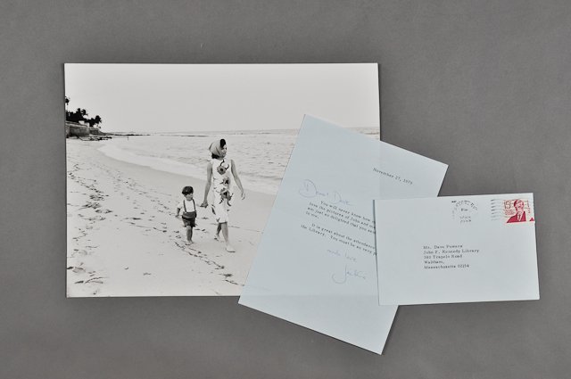 1979-Nov 27, Note Signed Jackie with Photo: (1) Photograph of John, Jr. and Jackie walking along the sands of a southern beach. 9" x 12". Taken by Mark Shaw in 1963. Creasing. (1) Page note with envelope to Dave Powers from Jackie thanking Dave