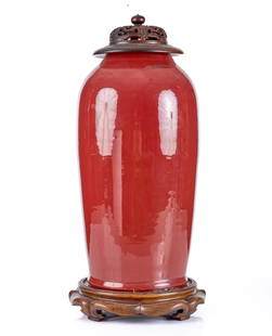 CHINESE GLAZED CERAMIC VASE with ROSEWOOD COVER: Cinnabar glaze, carved & pierced rosewood cover, and custom carved rosewood stand with paper label fragment. 19 1/2 inches excluding base. Condition: Abrasion/glaze defect. Temp No 2567