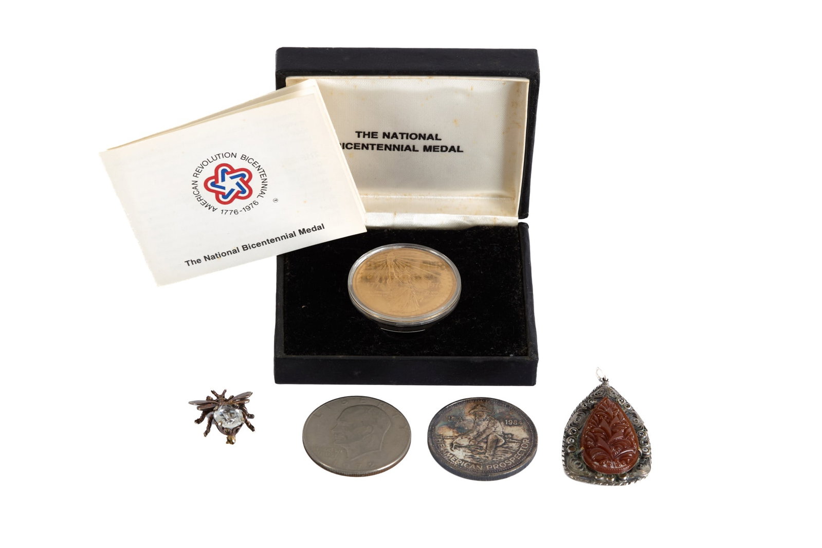 .999 SILVER COMMEMORATIVE a other ODDSOMES: Including: The American Prospector .999 Troy ounce, American Revolutionary National Bicentennial medal, Eisenhower dollar, bee pin and filigree pendant 2 inches (and smaller) Condition: Good Temp No 2