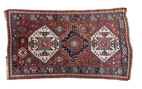 HAND WOVEN KAZAK ORIENTAL AREA RUG: Hand knotted wool rug with repeating geometric borders. 4 feet 3 inches x 7 feet 6 inches. Condition: Good. General wear from use. Temp No 2012