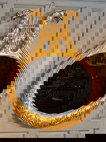 EARLY (19th c) AMERICAN CARVED & GILT EAGLE MIRROR: Surmounted by a pair of carved eagle heads joined by a stringed lyre motif entwined with ivy, with reeded and carved details, original plate. Albany, NY. 45 x 35 1/2 inches. Temp No 9037