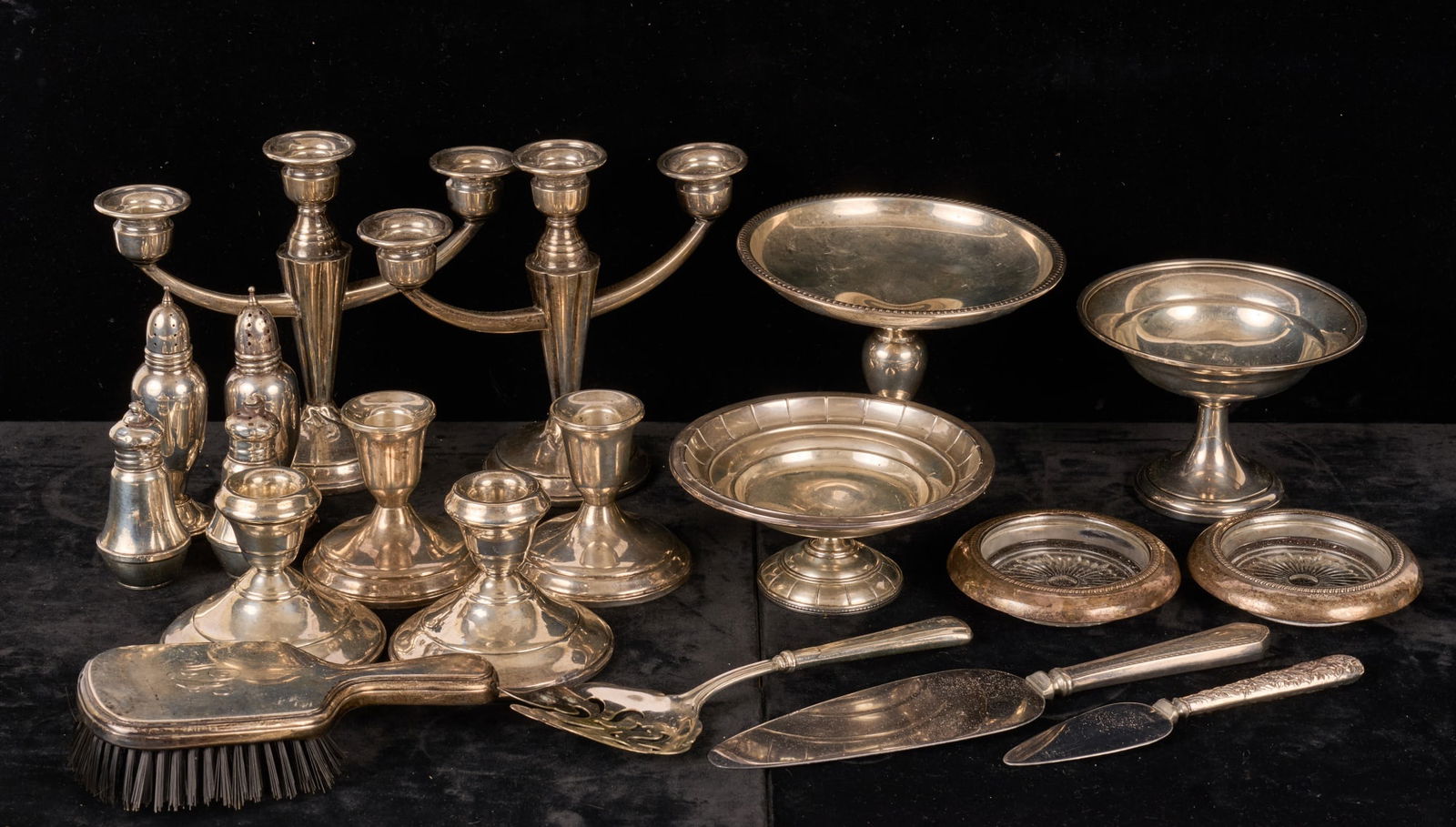 GROUPING of WEIGHTED STERLING SILVER WARES: Including: (3) Candlesticks, (3) compotes, (2) pair of salt and pepper shakers, a pair of coasters, (3) serving pieces and a hand brash. Condition: Good Temp No 7614