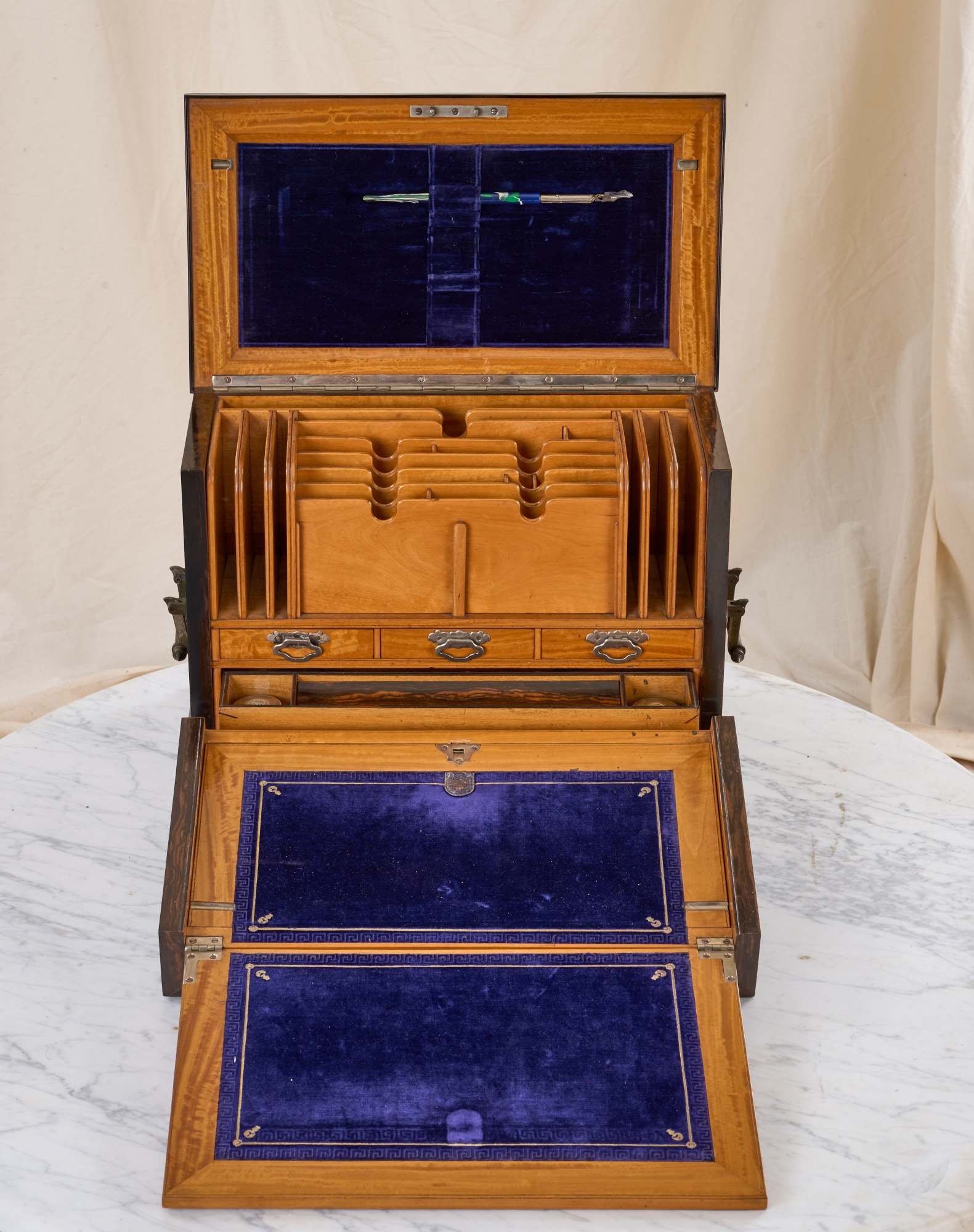 PARKINS and GATTO STATIONERY CABINET: Fall-front opens to a fold-out writing surface. Constructed in a vertical orientation with exceptional exotic wood (possibly bocote) and maple interior. Set with swinging brass aesthetic movement cast