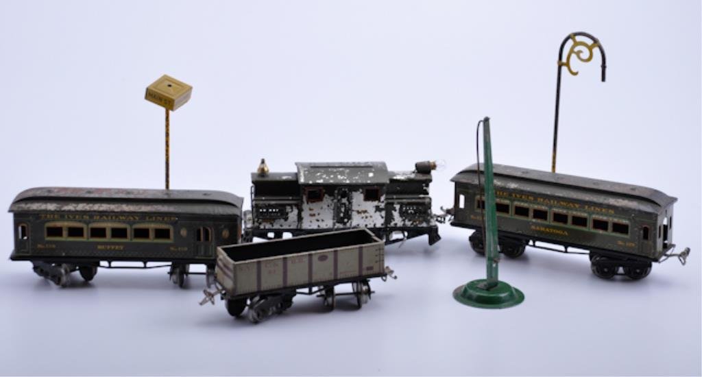 Train and Accessories: seven piece lot, IVES tin railway cars, Buffet Car 130, Seratoga Car #129, NYC HR #63, Engine 3253 and three various pieces. 9" (largest piece). Condition: flaking and losses