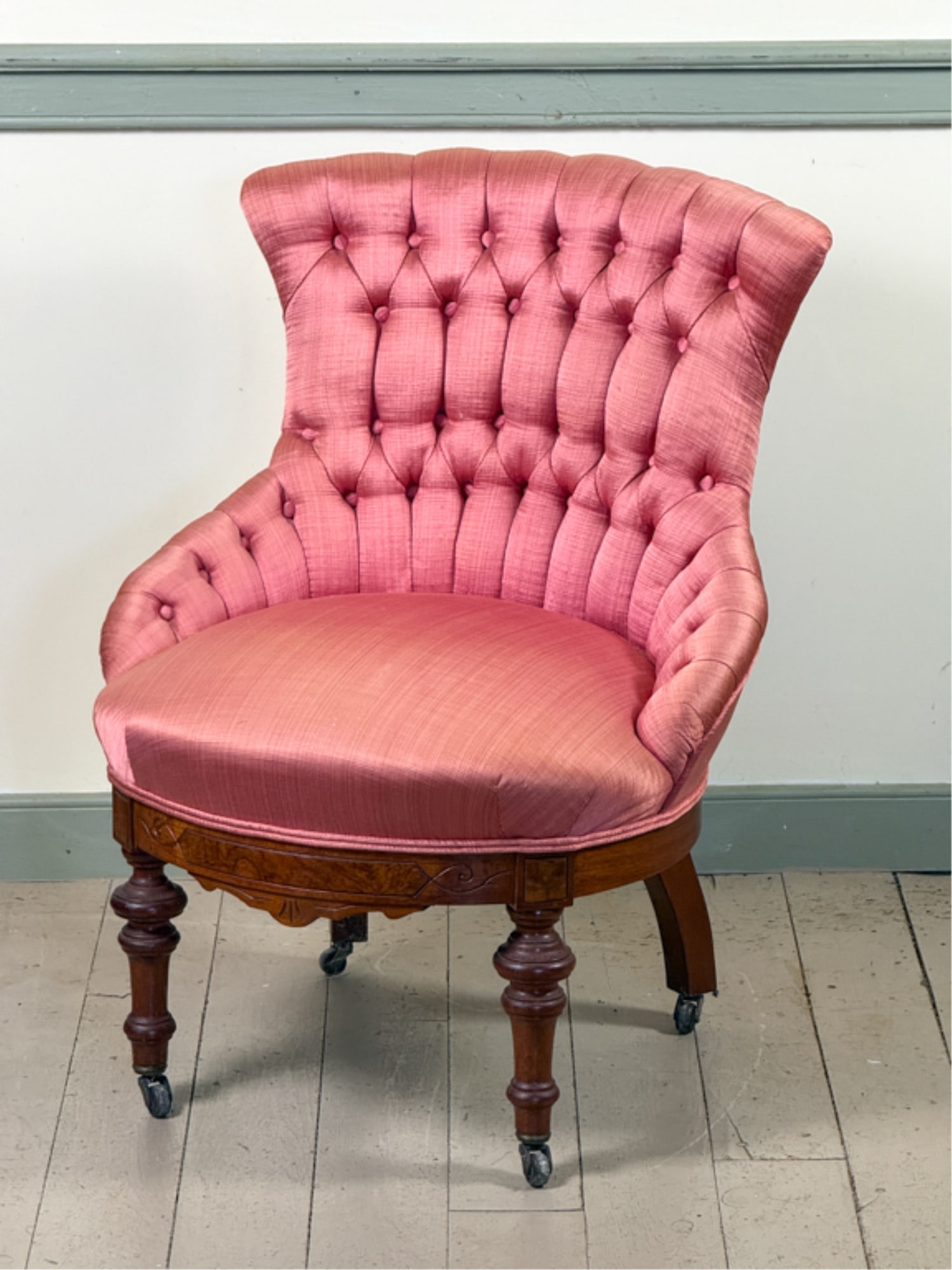 FINLEY UPHOLSTERED VICTORIAN WALNUT SLIPPER CHAIR: In salmon upholstery with carved accents on turned legs. 30 x 24 inches.