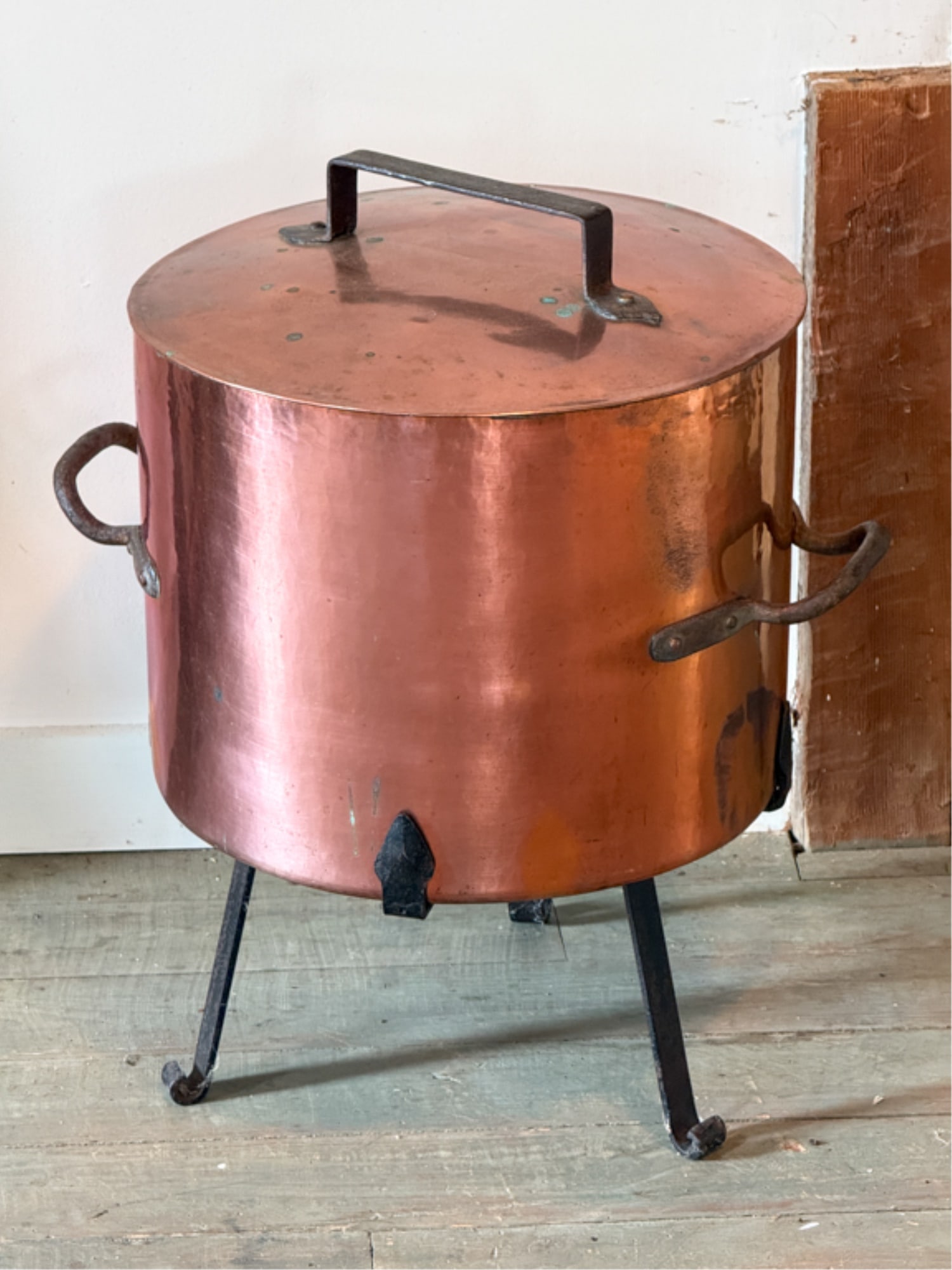 (19thc) COPPER POT ON WROUGHT IRON BASE: Hand wrought base with scrolled feet. 24 x 22 inches.