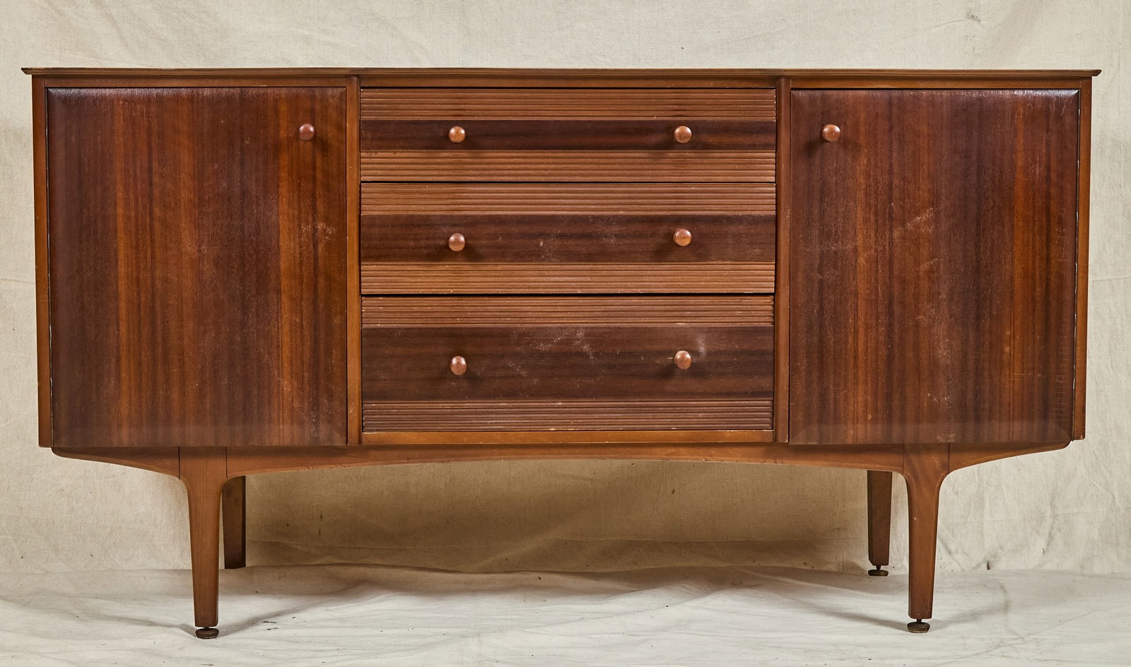 DIMINUTIVE MID-CENTURY LIFETIME WALNUT CREDENZA: Middle section with (3) graduated drawers displaying comb work, flanked by a cabinet with shelving on either side, raised on tapered legs. 31 x 57 x 16 inches.